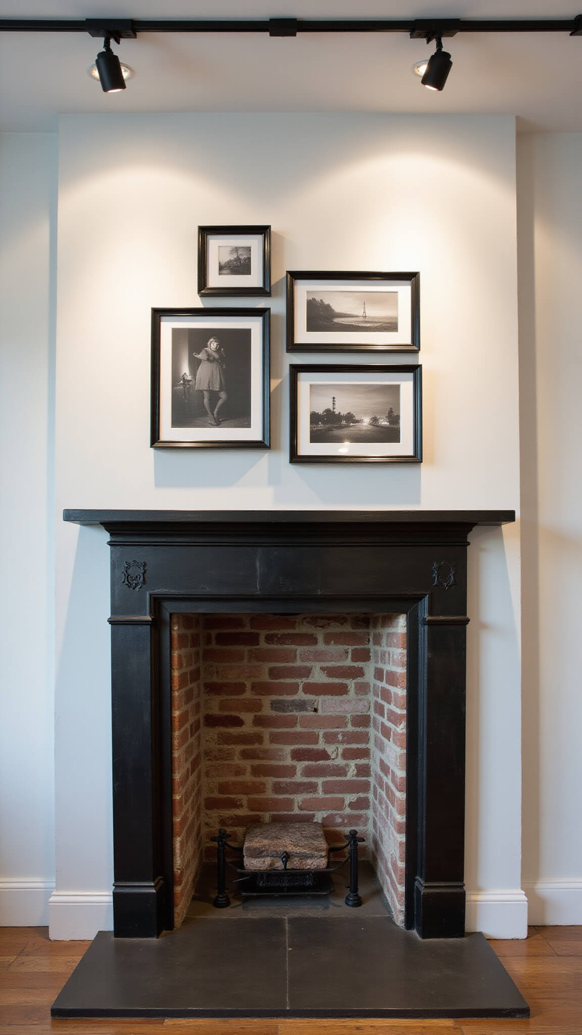 Urban lounge with blackened steel mantel, white painted brick fireplace, black and white photo arrangement, and dramatic track lighting.