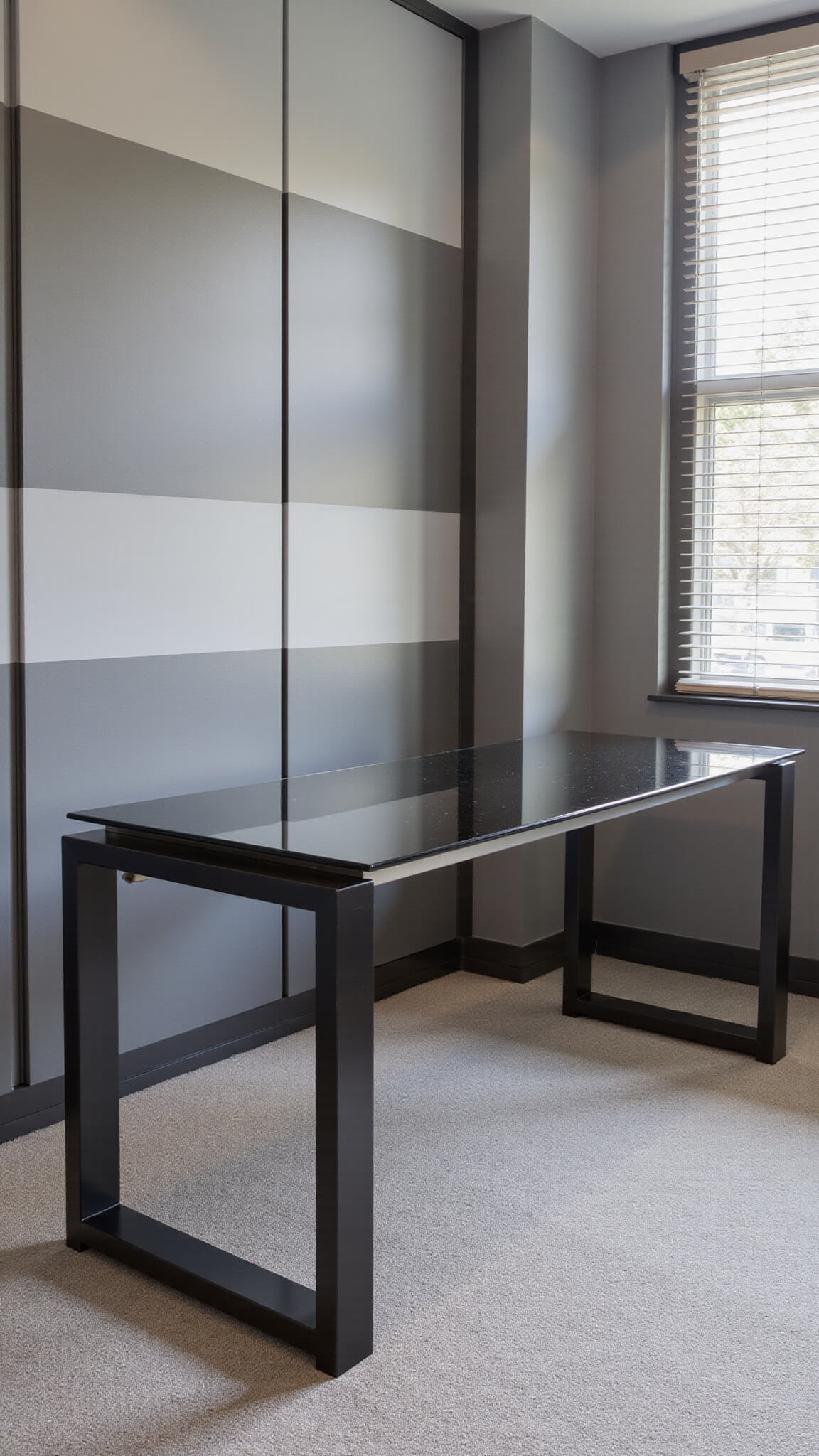 Smart home office with modular smoked glass and brushed steel desk, built-in storage hiding tech, gradient grey acoustic panels, and cool light filtering through motorized blinds.