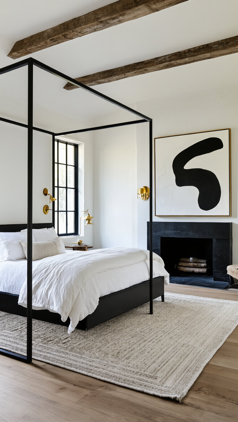 Midday corner view of a 15x17ft bedroom with black steel-framed windows, white lime-washed walls, a modern four-poster bed facing a black stone fireplace, oversized abstract art, and warm brass fixtures.