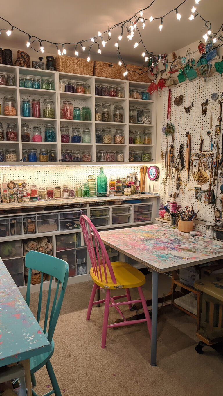 Eclectic craft room with string lights, colorful storage of jars and curiosities, candy-colored furniture, and pegboard of magical tools viewed from above.